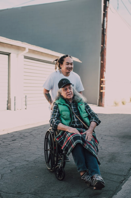 guy in a wheelchair with a carer