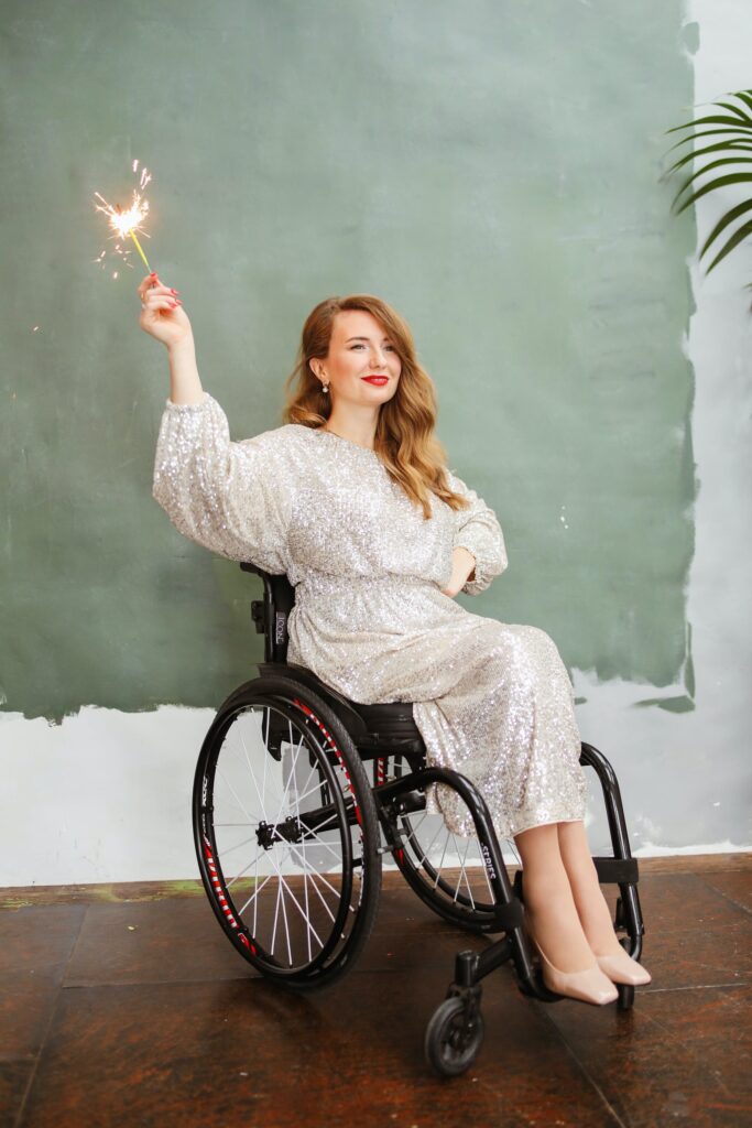 lady in wheelchair dressed glamorously assisted by a support worker